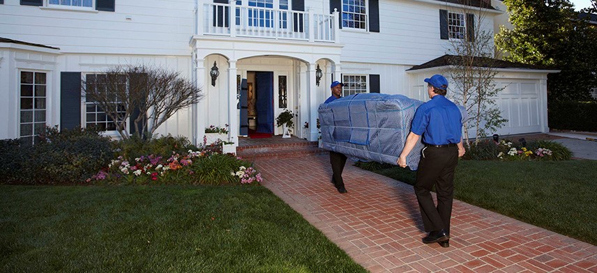 home movers carrying sofa into home