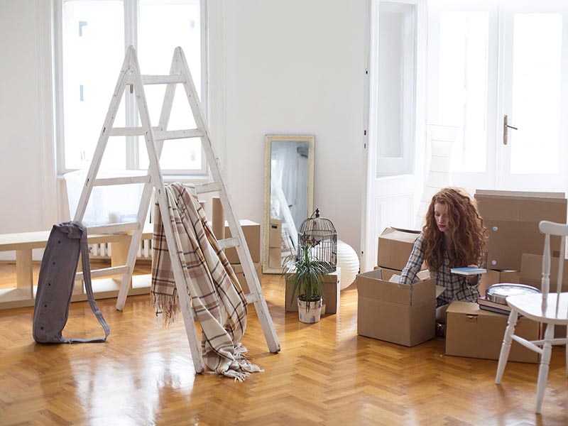 young woman packing moving boxes for home move