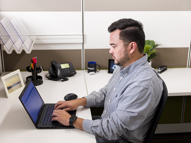 employee typing on laptop at desk