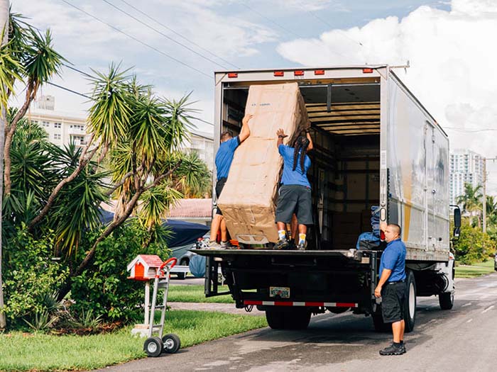 professional movers loading couch into moving truck