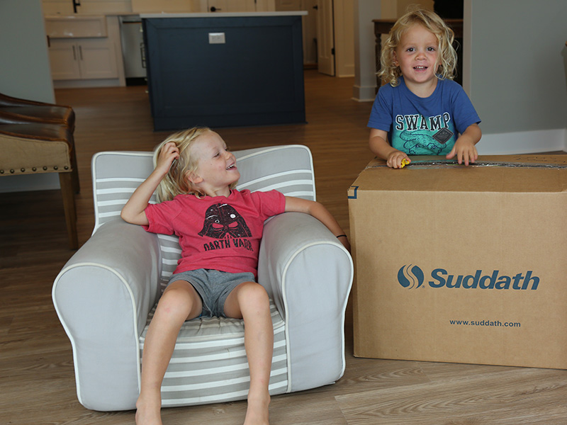 two young boys standing next to moving boxes