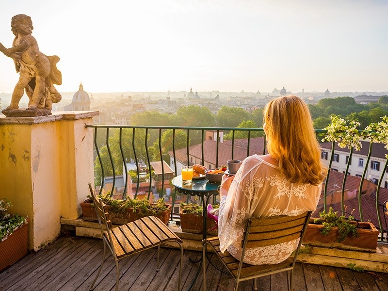 woman sitting at table on balcony in europe
