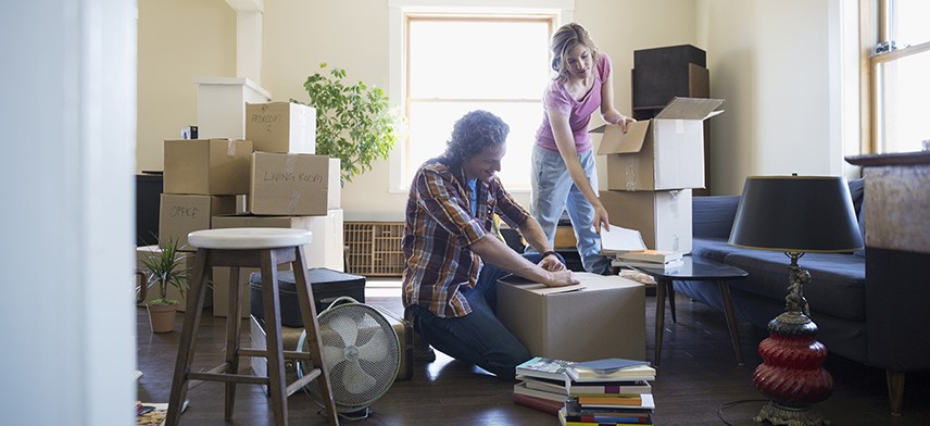 couple unpacking boxes in new home