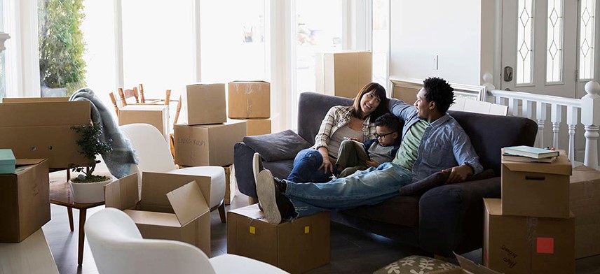 couple and son sitting on couch after home move