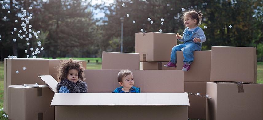 children sitting on top of leftover moving boxes