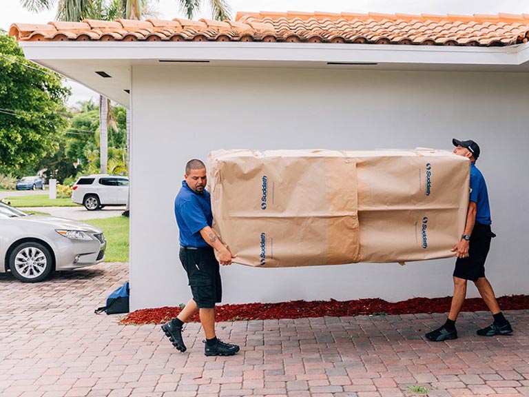 professional movers carrying couch out of home