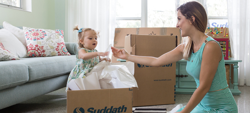 mother and daughter playing with moving box before international move
