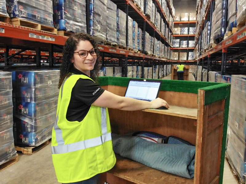 warehouse worker taking logistics inventory on laptop