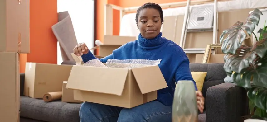 Person unpacking boxes in a cozy living room