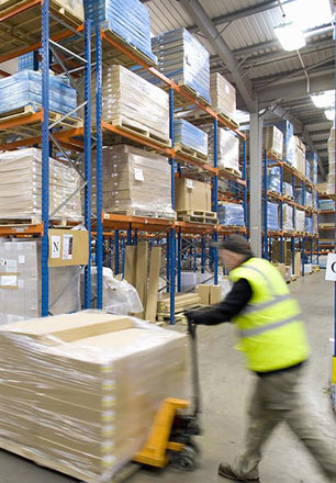 employee moving pallets at supply chain logistics warehouse