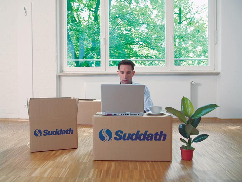 man using computer on top of moving boxes