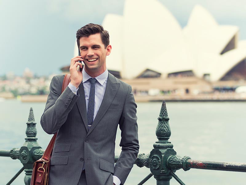 young professional expat smiling on phone in australia