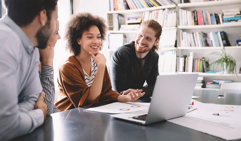 young professionals meeting laptop smiling